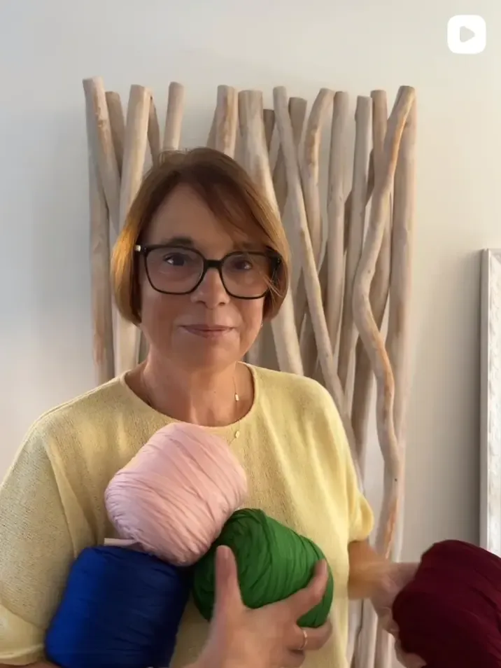 Karina et ses pelotes de fil rose, vert et bleu